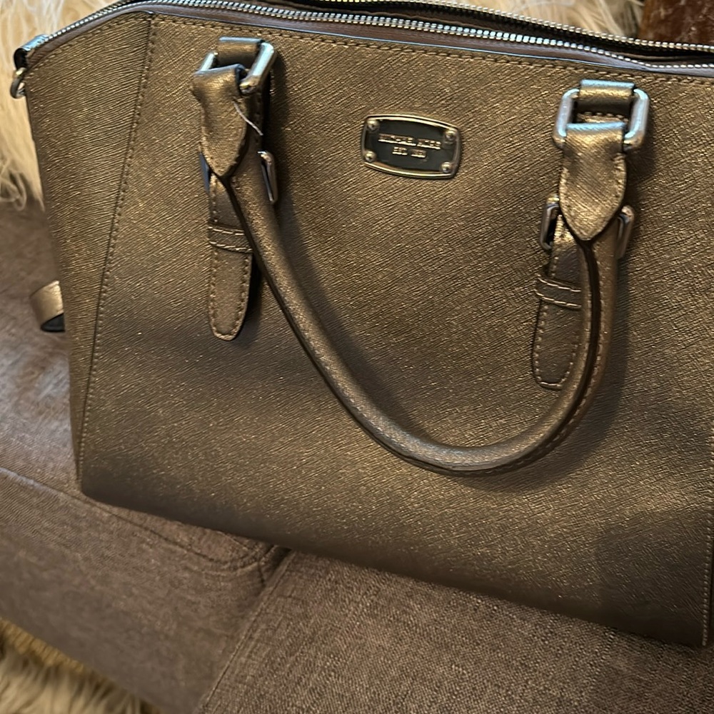 Michael Kors silver purse also worn as crossbody.
